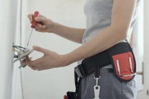 female electrician working on an electrical outlet