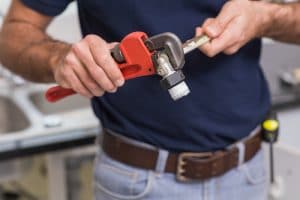 plumber working on a metal pipe