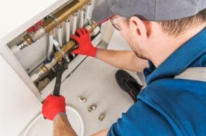 plumber wrenching on a copper pipe