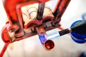 plumber heating up a copper pipe with a torch