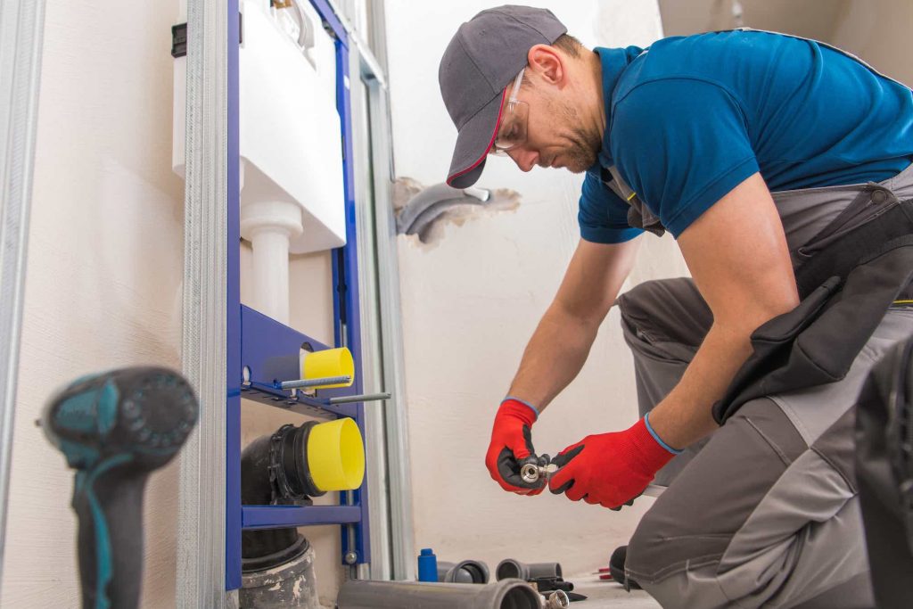 plumber installing pvc pipes in a home