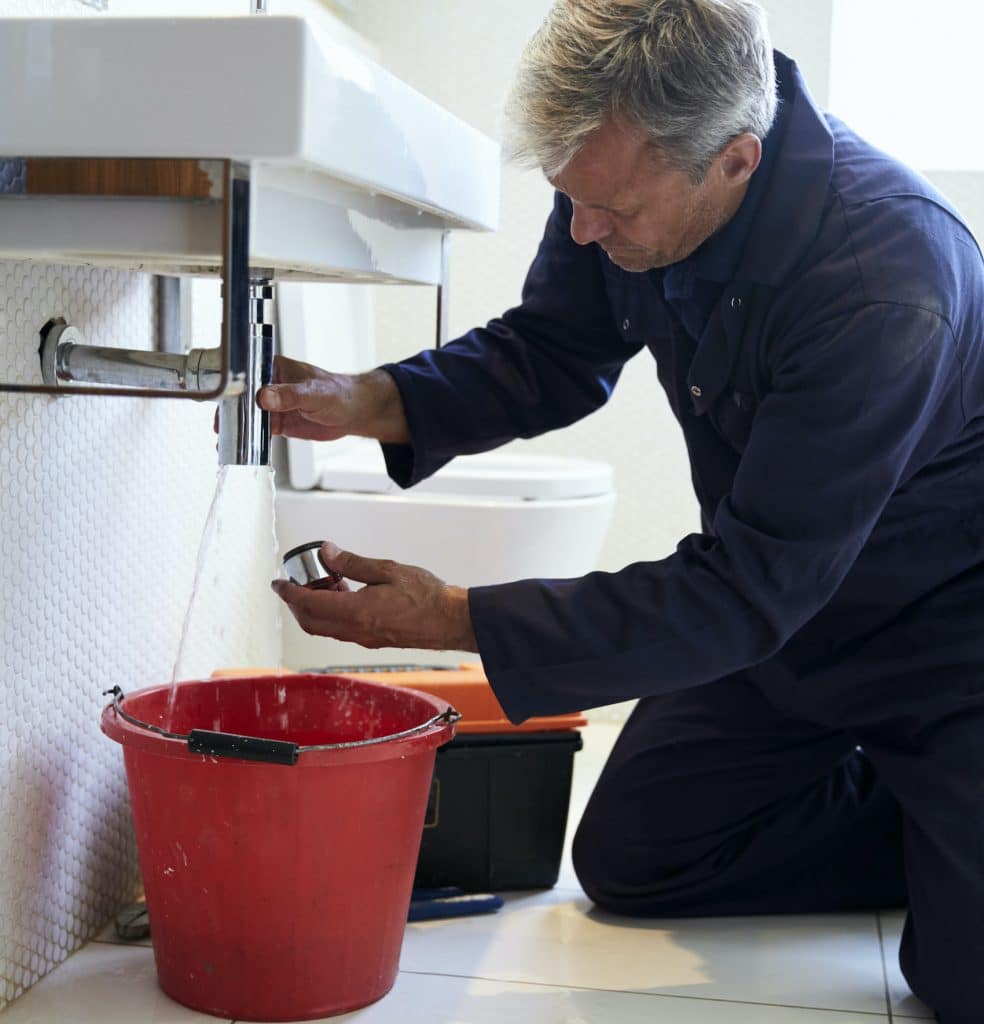 plumber cleaning sink drain pipes