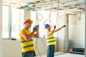 Electricians fixing the wire for the light installation in a residential home