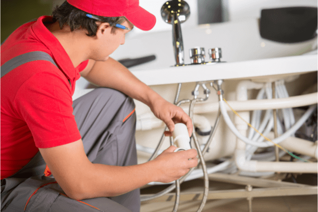 Plumber fixing some broken bathroom faucet