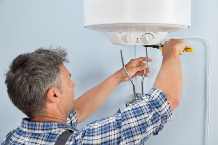 Technician servicing the gas boiler for hot water and heating.