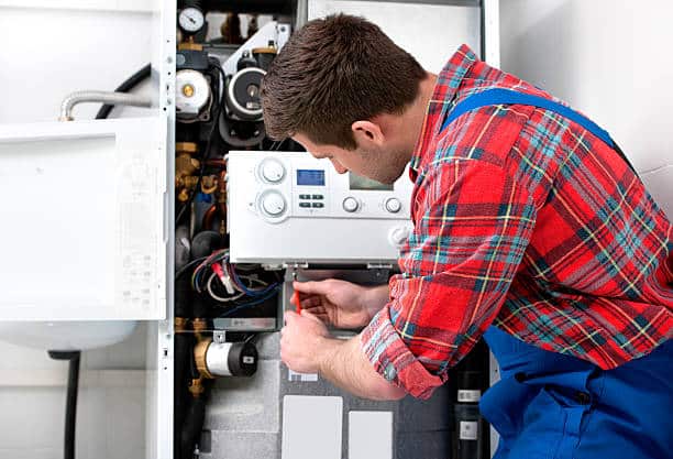 Technician servicing the gas boiler for hot water and heating.