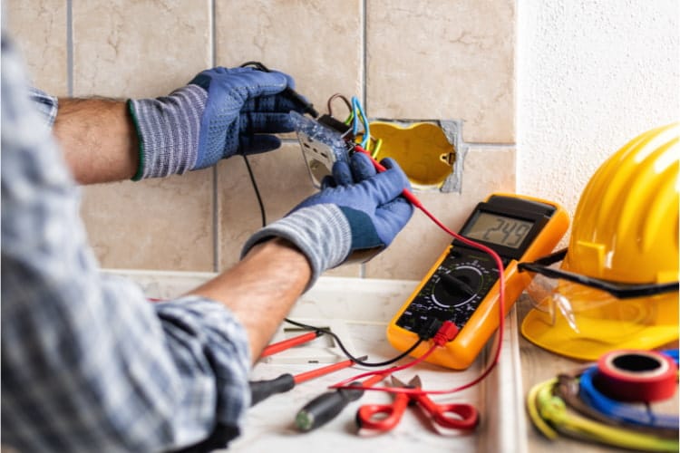 Electrician at work with safety equipment on a residential house.