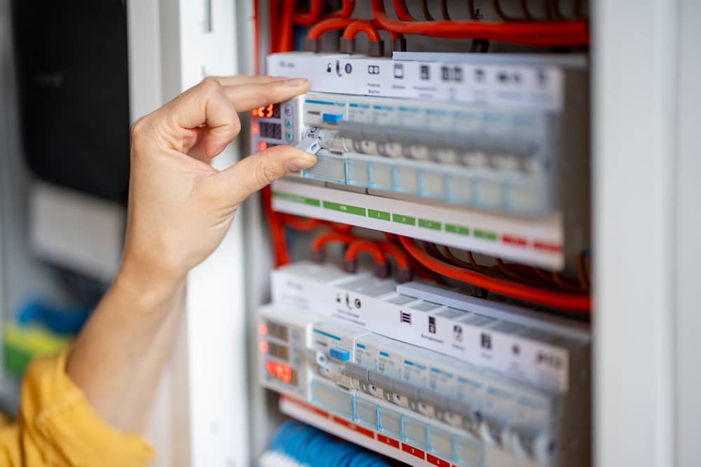 woman hand turn on the machine on the electrical panel at house after upgrade