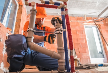 plumber working on pipes as preventive measure for future damage and clogs