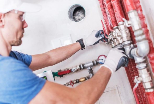 professional plumber working on water pipes on an industrial building