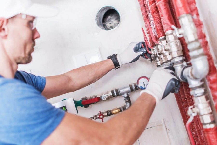 professional plumber working on water pipes on an industrial building